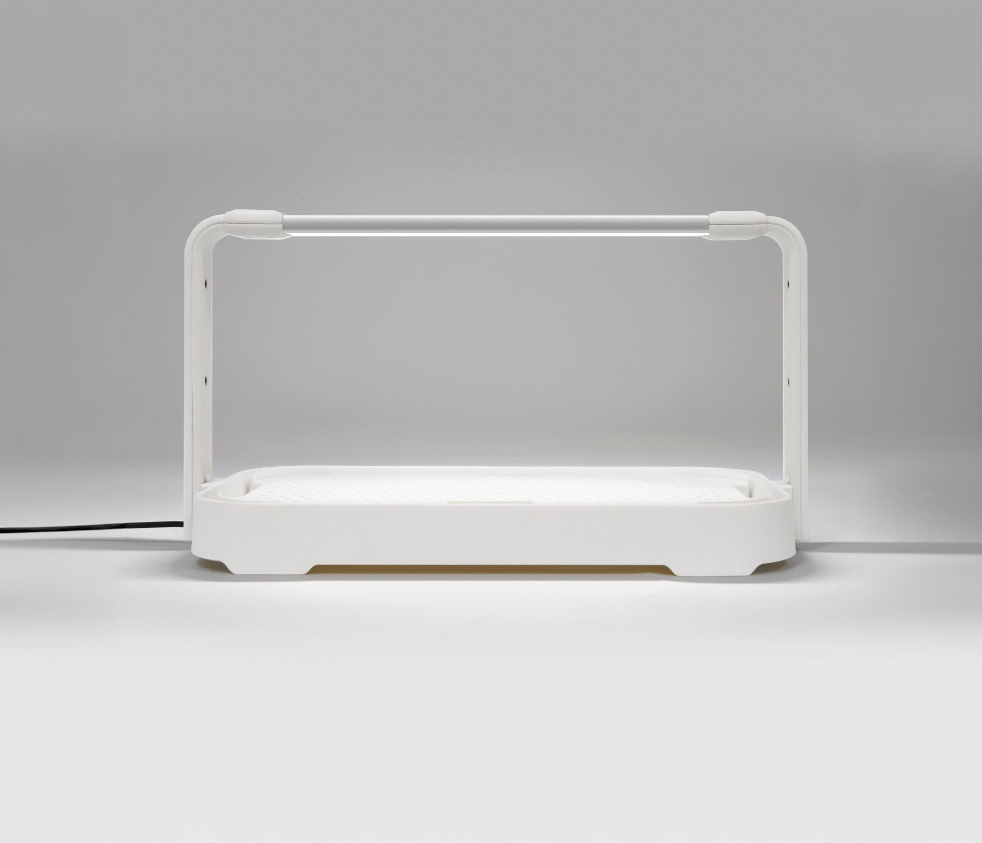 Entry-level white microgreen garden system with LED grow light used for indoor gardening.