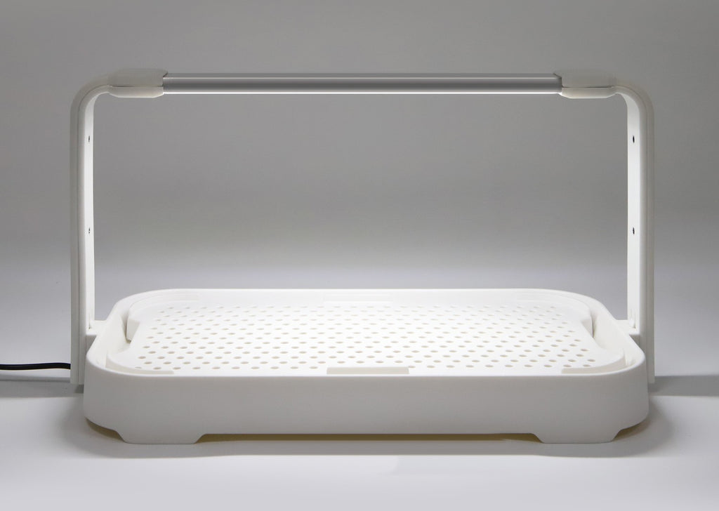 Close-up of the white microgreen garden showing its efficient 10W LED grow light turned on for indoor gardening.