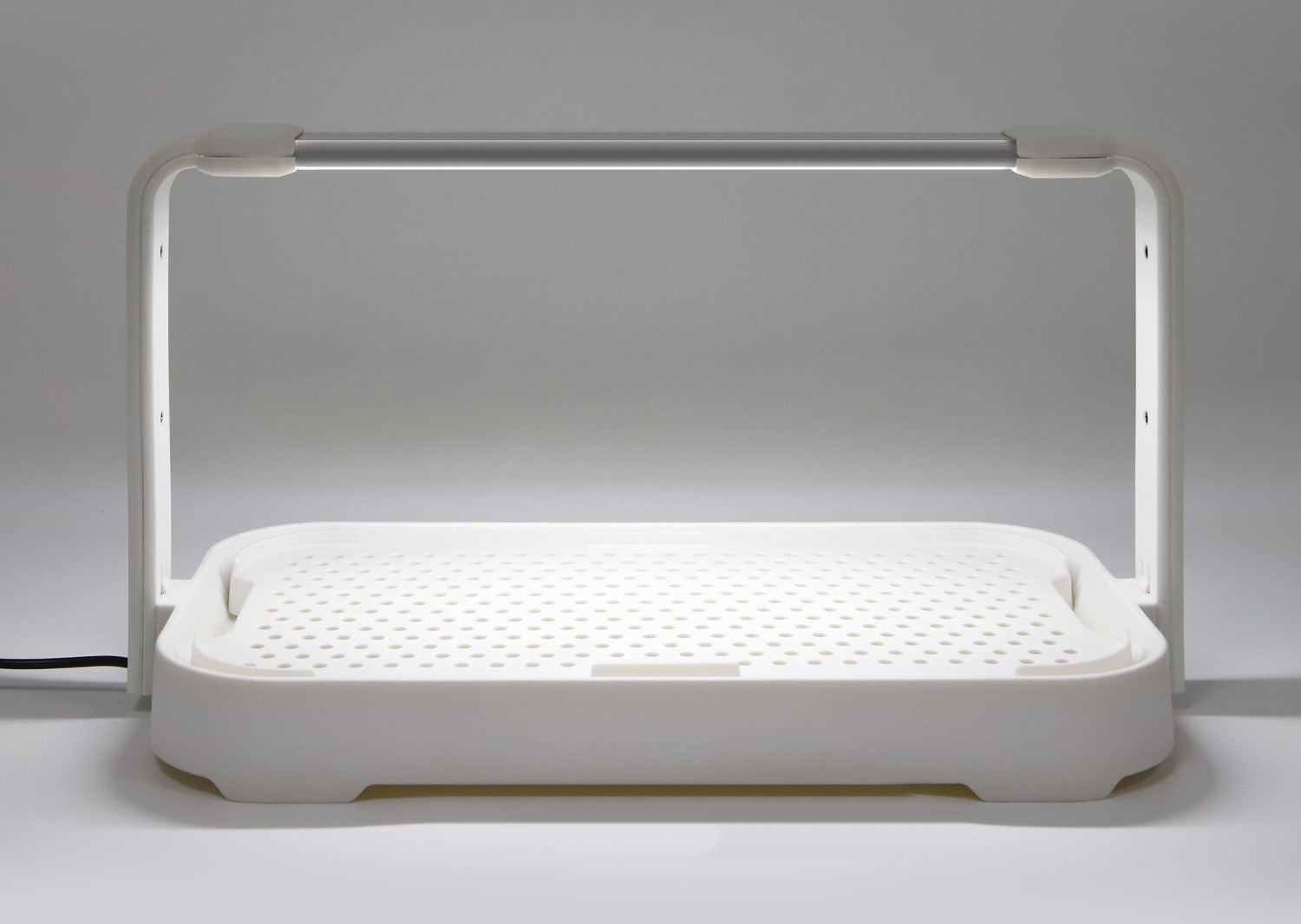 Close-up of the white microgreen garden showing its efficient 10W LED grow light turned on for indoor gardening.