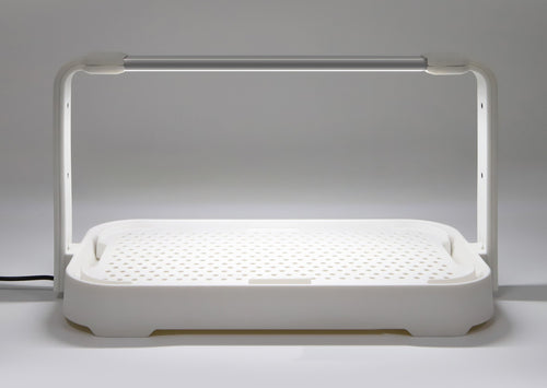 Close-up of the white microgreen garden showing its efficient 10W LED grow light turned on for indoor gardening.